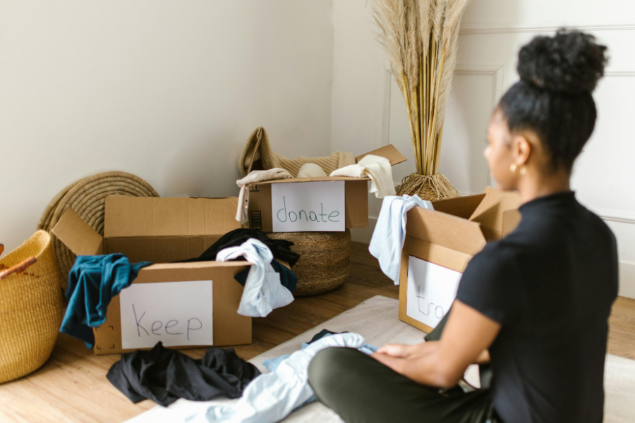 Un personne seule et dubitative devant les trois cartons de tri : A vendre, A donner, A garder crédit photo: rdne-stock-project-pixels